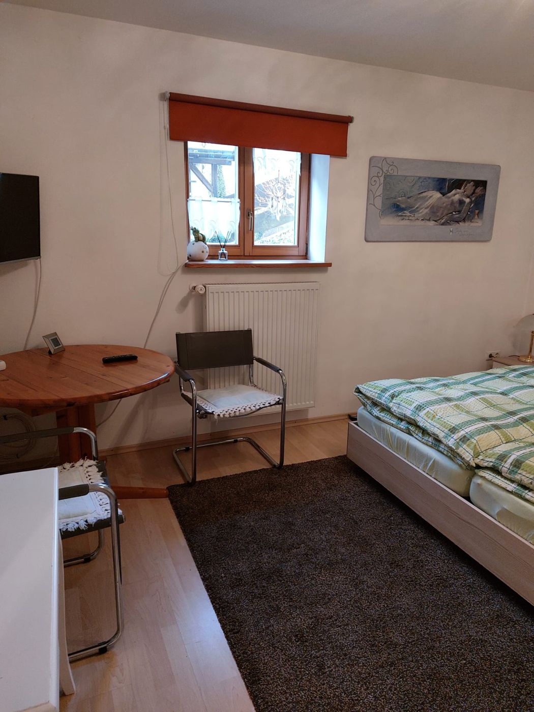 Schlafzimmer mit Tisch und Fernseher
