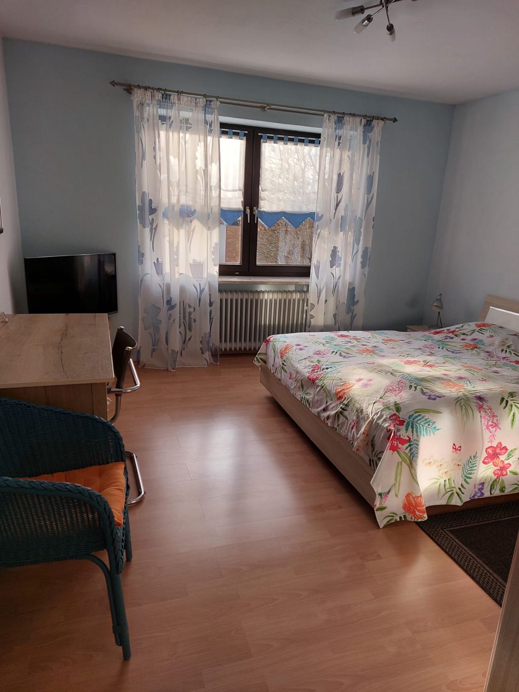 Schlafzimmer mit Doppelbett, Schreibtisch und Fernseher